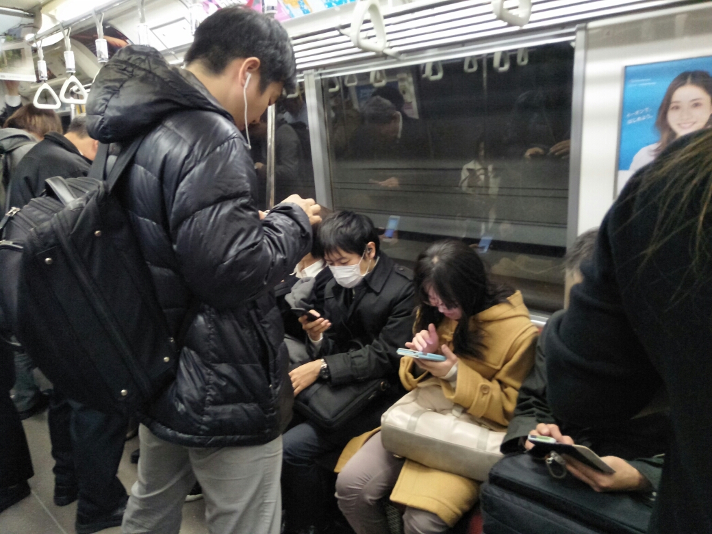 东京地铁里玩手机的人们